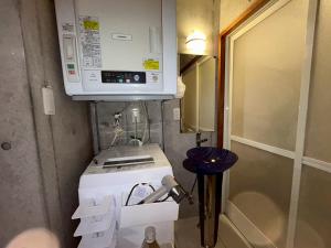 a kitchen with a microwave and a coffee maker at オランウータンApple House Ginowan in Ginowan +76 photos