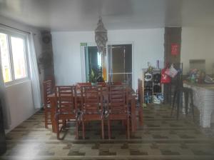 a dining room with a table and chairs at Koa's Beach House in Tangalan