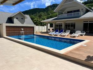 a swimming pool in front of a house at Wyn Villa in Praslin