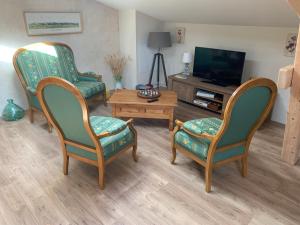 a living room with two chairs and a tv at Maison d'hôtes "La Clef des Champs" Piscine Ortance in Sajas