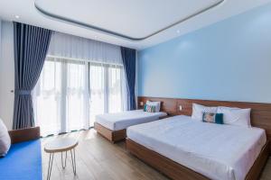 a hotel room with two beds and a table at Cocohamlet Villa in Thanh Ðông (1)