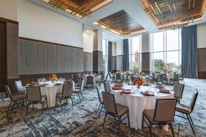 a banquet hall with tables and chairs and large windows at Thompson San Antonio - Riverwalk, by Hyatt in San Antonio