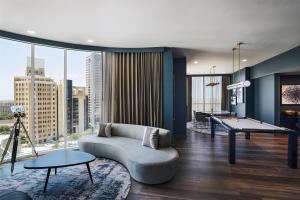 a living room with a couch and a pool table at Thompson San Antonio - Riverwalk, by Hyatt in San Antonio