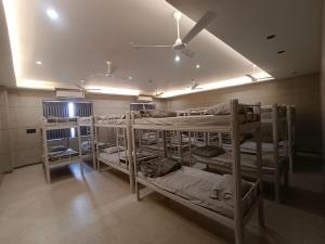 a room with three bunk beds and a ceiling at Sarju Palace Dormetry in Valsād