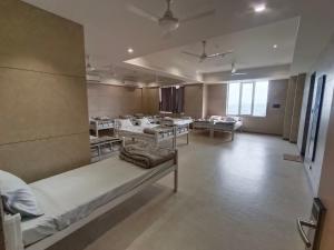 a large room with beds and tables in it at Sarju Palace Dormetry in Valsād