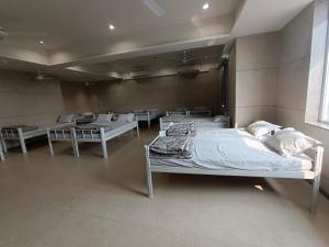 a hospital room with several beds and tables at Sarju Palace Dormetry in Valsād