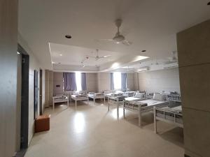 a hospital room with chairs and tables and windows at Sarju Palace Dormetry in Valsād