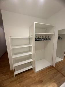 a white closet with white shelves in a room at SeePERLE 131 in Friedrichshafen