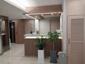an office lobby with a reception counter and plants at Hotel BELLUS in Busan