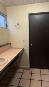 a bathroom with a black door and a sink at Not for rent in Mazatlán