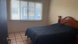 a bedroom with a bed and a window with blinds at Not for rent in Mazatlán