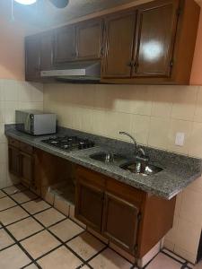 a kitchen counter with two sinks and a stove at Not for rent in Mazatlán