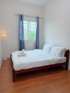 a bedroom with a large bed with a window at EQAMEL Homestay 2 in Sandakan