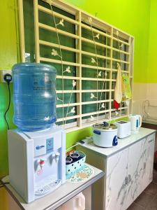 a kitchen with a counter with a stove and a container at EQAMEL Homestay 2 in Sandakan +19 photos
