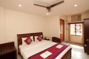 um quarto com uma cama e uma ventoinha de tecto em Lloyds Serviced Apartments, Near Music Academy em Chennai