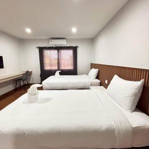 a bedroom with two beds and a desk at Ma Relax Place in Ban Hau Chang