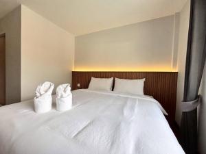 a large white bed with two white towels on it at Ma Relax Place in Ban Hau Chang