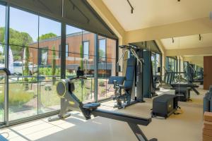 a gym with treadmills and ellipticals and windows at Les Bungalows in Torbalı