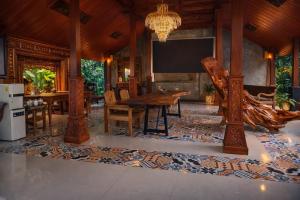 a dining room with a table and a tv at Mahatva Borobudur Resort in Borobudur