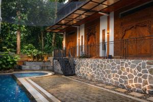 a house with a swimming pool next to a house at Mahatva Borobudur Resort in Borobudur