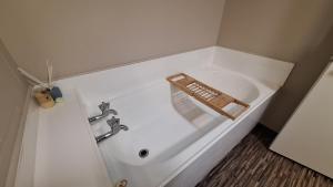 a white bath tub with a faucet in a bathroom at Relax on Robertson in Queenstown +13 photos