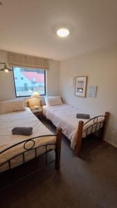 a bedroom with two beds and a window at Relax on Robertson in Queenstown