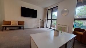 a living room with a tv and a couch at Relax on Robertson in Queenstown