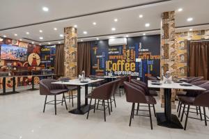 a restaurant with tables and chairs and a coffee wall at Treebo Sri Krishna Palace in Bhubaneshwar