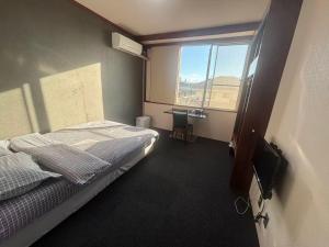 a bedroom with a bed and a window at ホテルルネサンス土浦 in Tsuchiura