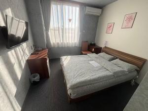 a bedroom with a bed and a desk and a window at ホテルルネサンス土浦 in Tsuchiura +8 photos
