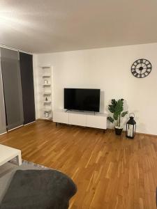 a living room with a flat screen tv on a white wall at SeePERLE 131 in Friedrichshafen