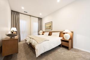 a bedroom with a large bed and two lamps at Shining House Villa A in Tanunda