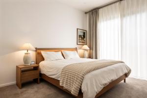 a bedroom with a bed and a large window at Shining House Villa A in Tanunda +6 photos