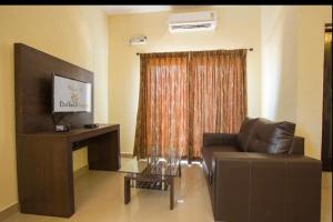 a living room with a couch and a television at Daffodil Suites, Manyata Tech Park, Bengaluru in Bangalore +5 photos