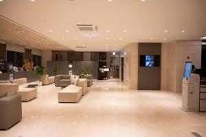a lobby with couches and chairs in a building at Hotel Gracery Seoul in Seoul