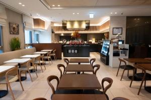 a restaurant with tables and chairs and a counter at Hotel Gracery Seoul in Seoul