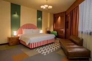 a hotel room with a bed and a chair at The Très Hotel in Kuala Lumpur