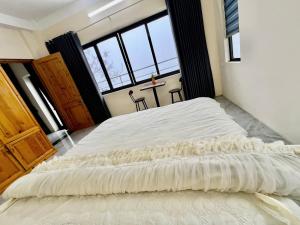 a large white bed in a room with large windows at Lùma Sapa Homestay in Sapa +11 photos