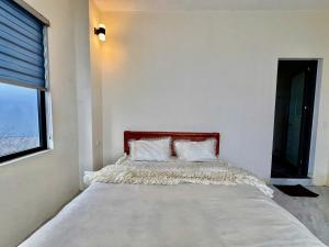 a large bed in a room with a window at Lùma Sapa Homestay in Sapa