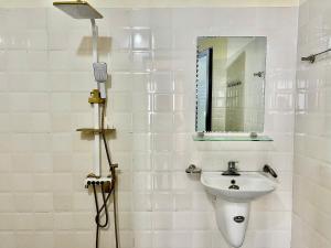 a white bathroom with a sink and a mirror at Lùma Sapa Homestay in Sapa