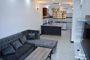 a living room with a couch and a kitchen at Kivuli suites in Eldoret