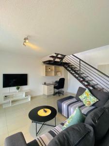 ein Wohnzimmer mit Sofa und Treppe in der Unterkunft City Duplex Trift Towers Apartment in Windhoek