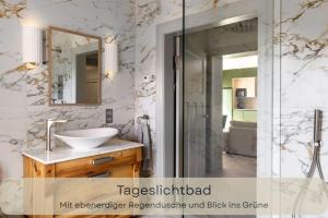 a bathroom with a sink and a glass shower at Hufe 9 Gute Stube - Digital Detox und Entschleunigen oder Aktiv-Urlaub in der Natur - Bauernhof Charme trifft modernes Design in Wustrow