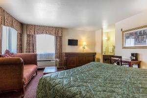 a hotel room with a bed and a couch at Rodeway Inn Magic Mountain Area in Castaic