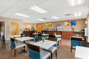 a dining room with tables and chairs and a counter at Comfort Inn & Suites Wildwood - The Villages in Wildwood