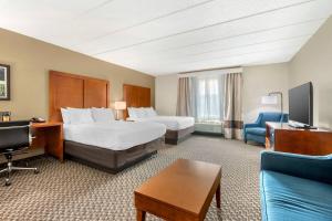 a hotel room with two beds and a couch at Comfort Inn & Suites Wildwood - The Villages in Wildwood