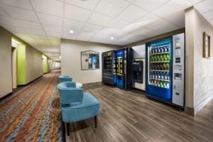 a lobby with two vending machines and blue chairs at Sleep Inn & Suites Valdosta Mall Area in Valdosta