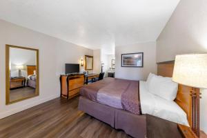 a hotel room with a bed and a mirror at Rodeway Inn at Nevada State Capitol in Carson City