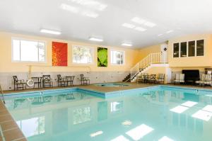 a large swimming pool with chairs and tables at Comfort Inn & Suites Ashland in Ashland