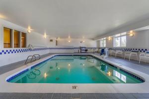 a large pool in a hotel with chairs and a table at Comfort Inn Kennewick Richland in Kennewick